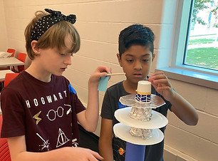 Photo of two kids making a rocket model